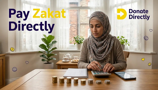 Person calculating Zakat with coins and notebook in a UK home setting, representing nisab threshold understanding.